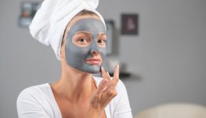 Giovane donna cura la pelle con una maschera