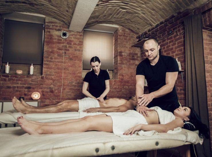 Massaggio all'addome fatto da due massaggiatori professionisti