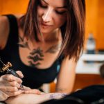 Tatuatrice con tatuaggio in mezzo al seno