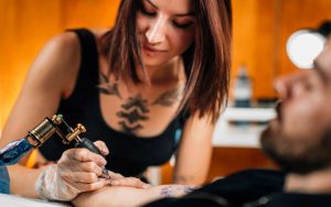 Tatuatrice con tatuaggio in mezzo al seno